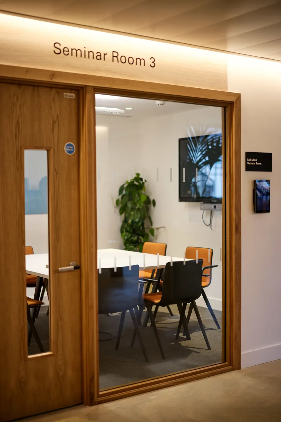 The glazed door of Seminar Room 3, with a meeting table and chairs inside